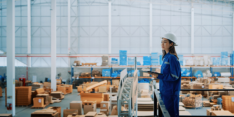 Female Engineer Overseeing Warehouse Operations in Safety Gear